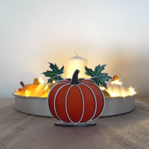 Jesienna dynia z liśćmi na podstawce